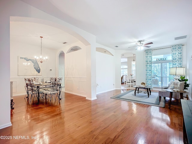 interior space featuring wood-type flooring and ceiling fan with notable chandelier