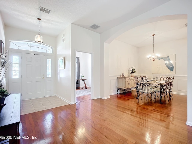 entrance foyer with an inviting chandelier, light hardwood / wood-style flooring, and a textured ceiling