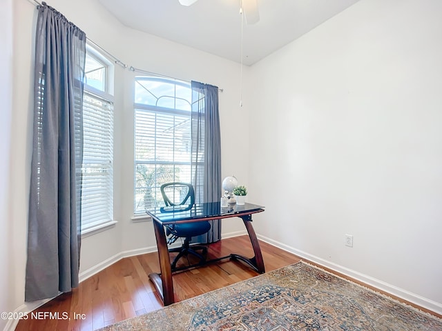 home office with wood-type flooring and ceiling fan