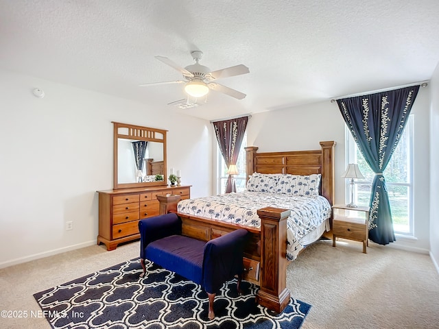 carpeted bedroom featuring ceiling fan and a textured ceiling