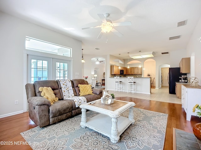 living room with ceiling fan and light hardwood / wood-style floors