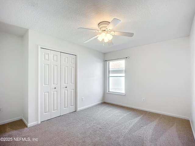 unfurnished bedroom featuring carpet, a textured ceiling, and a closet