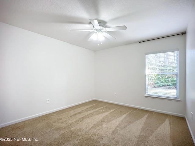 carpeted empty room featuring ceiling fan and a textured ceiling