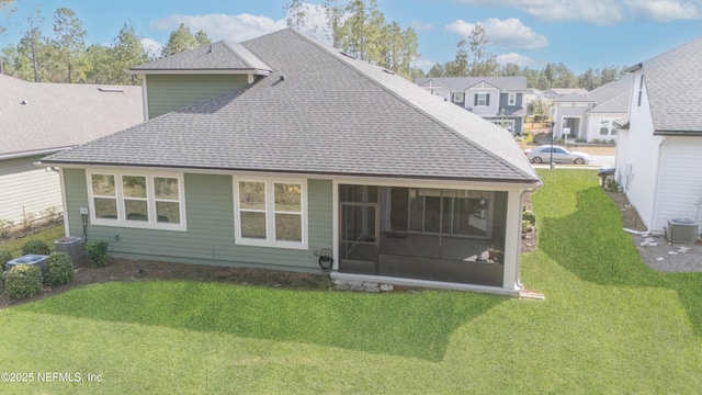 back of house with a sunroom, a lawn, and central air condition unit