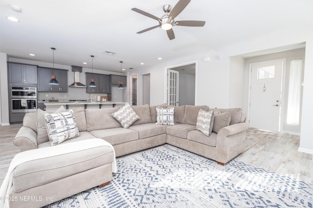 living room featuring ceiling fan and light hardwood / wood-style floors