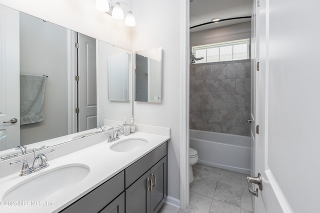 full bathroom with tiled shower / bath combo, vanity, and toilet