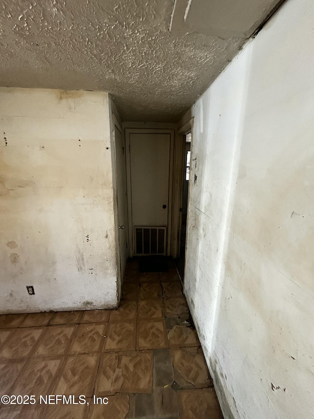 corridor featuring a textured ceiling