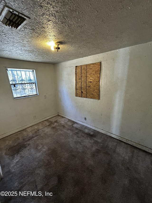 carpeted spare room featuring a textured ceiling