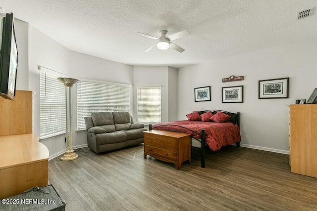 bedroom featuring ceiling fan, dark hardwood / wood-style floors, and a textured ceiling