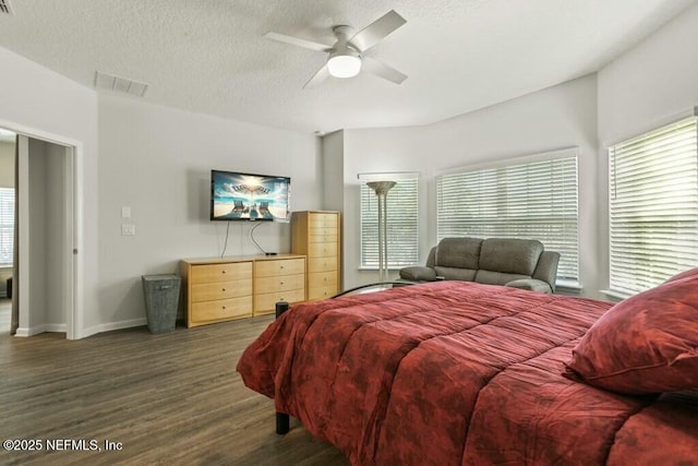 bedroom with ceiling fan, dark hardwood / wood-style floors, and a textured ceiling