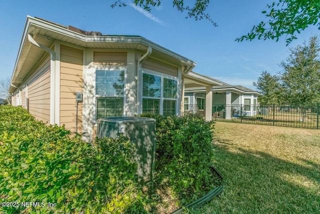 view of side of property featuring a yard and central AC unit