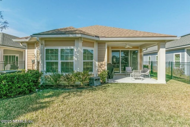 rear view of property featuring a patio, a yard, and ceiling fan