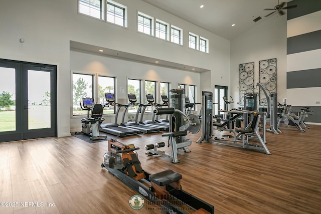 gym with hardwood / wood-style flooring and french doors