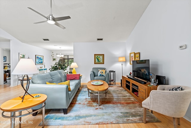 living room featuring hardwood / wood-style flooring and ceiling fan with notable chandelier