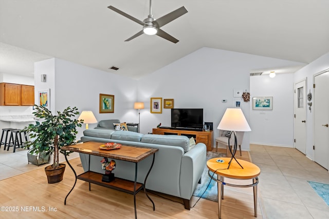 tiled living room featuring ceiling fan and lofted ceiling