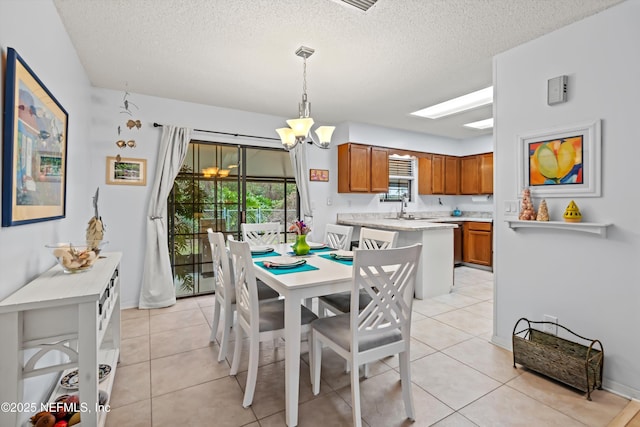 tiled dining room with an inviting chandelier, sink, and a textured ceiling