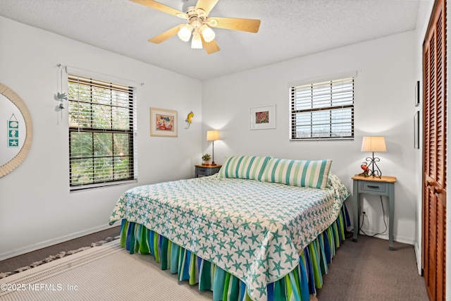 carpeted bedroom featuring ceiling fan, multiple windows, and a textured ceiling