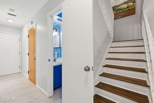 stairs featuring sink and tile patterned floors