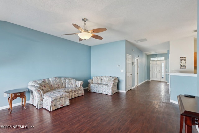 sitting room with dark wood-type flooring, ceiling fan, and a textured ceiling