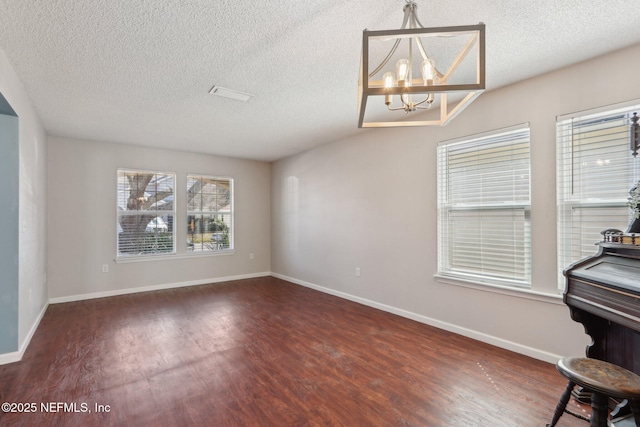 interior space featuring a chandelier, a textured ceiling, and dark hardwood / wood-style flooring