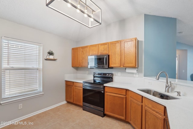 kitchen with lofted ceiling, sink, light tile patterned floors, appliances with stainless steel finishes, and a textured ceiling