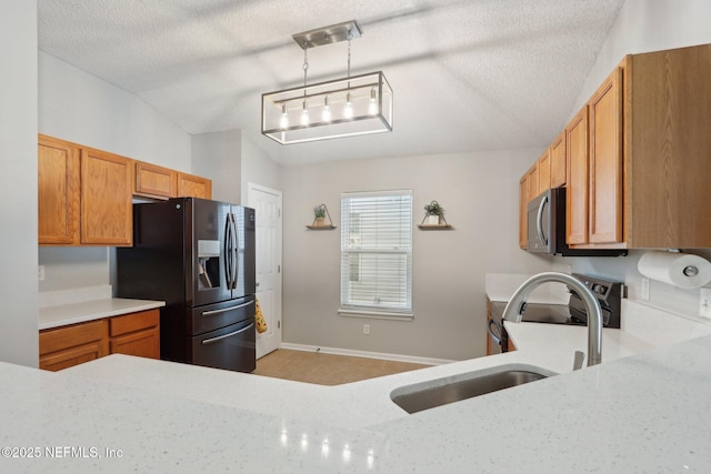 kitchen with sink, black refrigerator with ice dispenser, a textured ceiling, pendant lighting, and stove