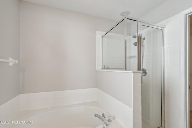 bathroom with separate shower and tub and a textured ceiling