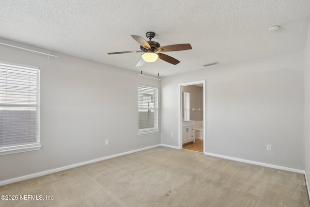 carpeted spare room with ceiling fan and a textured ceiling