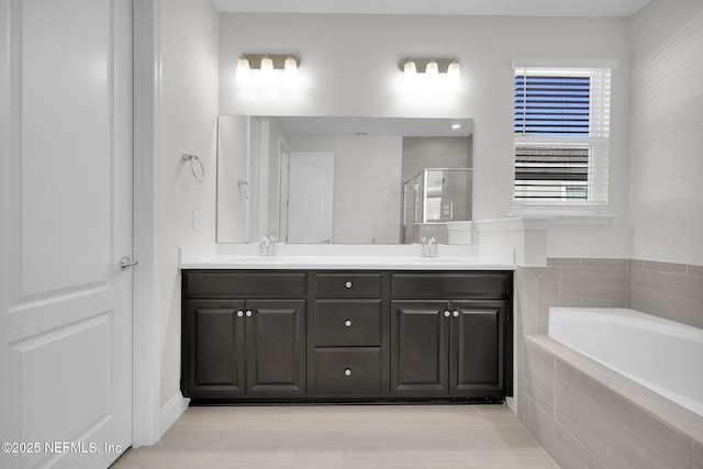 bathroom featuring vanity and shower with separate bathtub