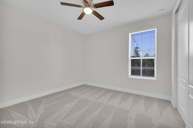 carpeted spare room featuring ceiling fan