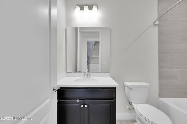 full bathroom with vanity, tiled shower / bath combo, and toilet