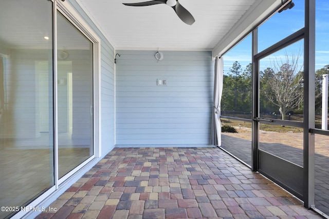 unfurnished sunroom featuring ceiling fan