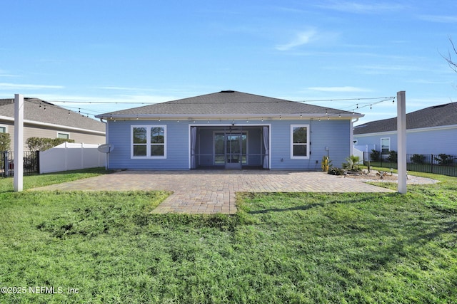 back of property with a yard and a patio area