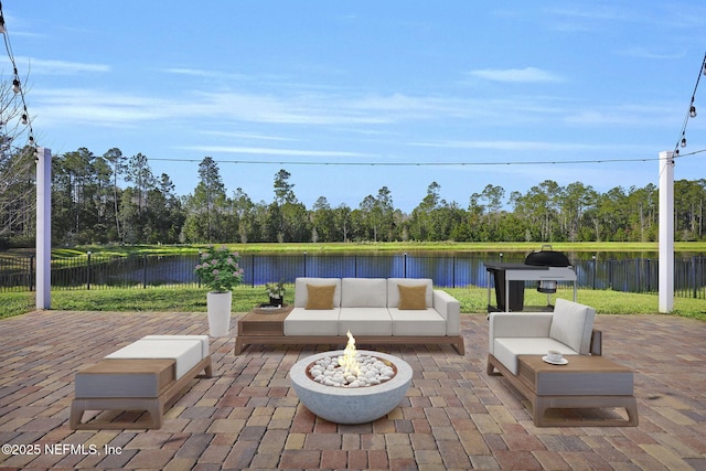 view of patio / terrace featuring a water view and an outdoor living space with a fire pit