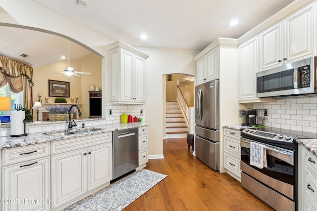 kitchen with sink, appliances with stainless steel finishes, ceiling fan, light hardwood / wood-style floors, and white cabinets