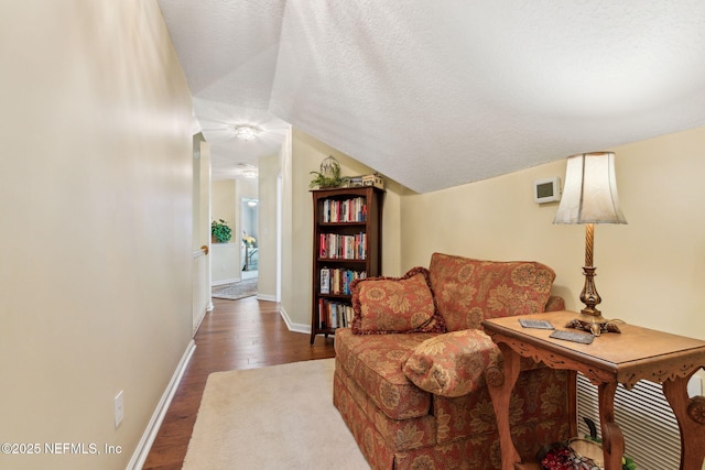 living room with lofted ceiling, dark hardwood / wood-style floors, and a textured ceiling