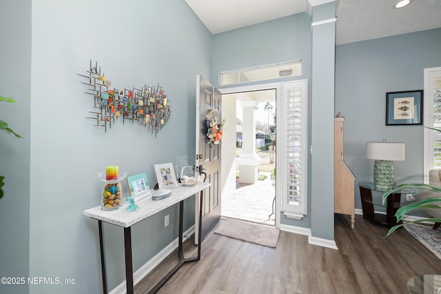 entryway with dark hardwood / wood-style floors and decorative columns