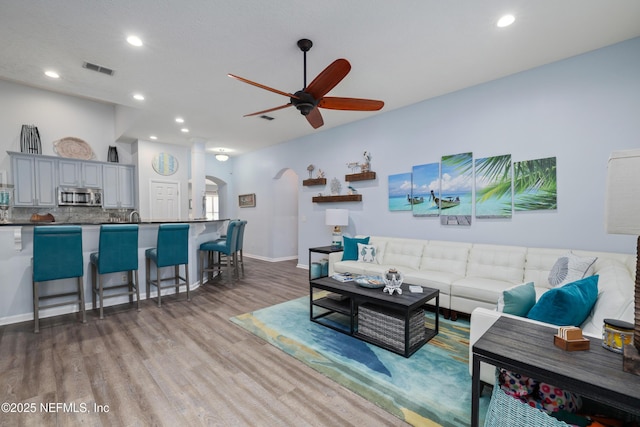 living room with ceiling fan and hardwood / wood-style floors