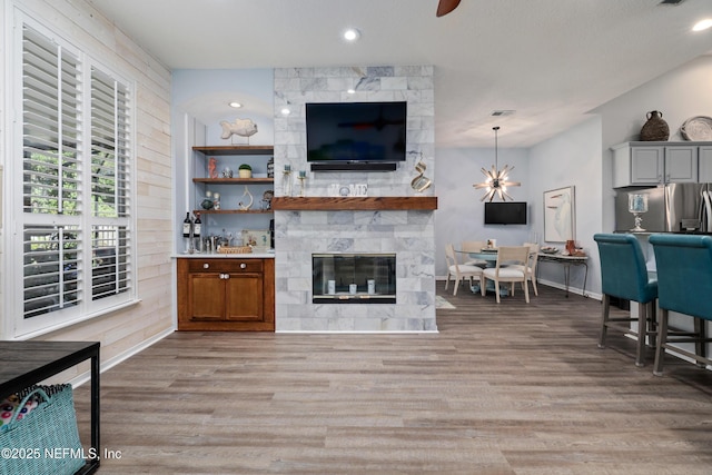 living room with light hardwood / wood-style floors and a large fireplace