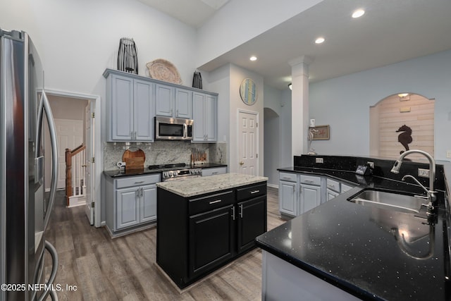 kitchen featuring stainless steel appliances, a kitchen island, sink, and hardwood / wood-style floors