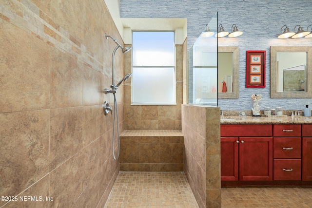 bathroom with vanity and a tile shower