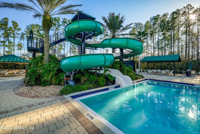 view of swimming pool with a patio and a water slide