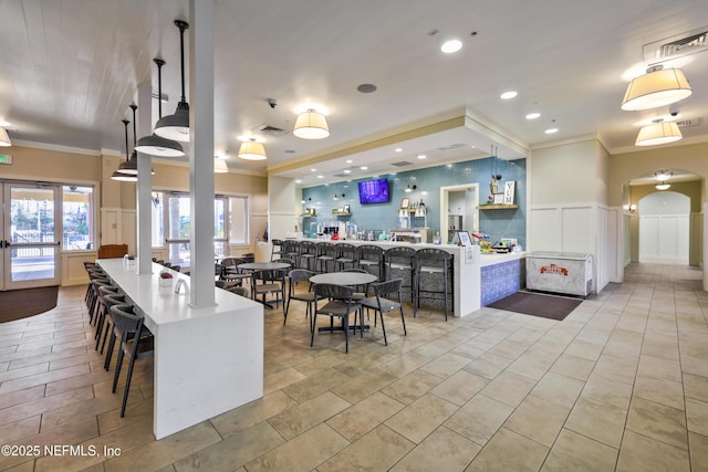 kitchen with ornamental molding, a large island, a breakfast bar area, and decorative light fixtures