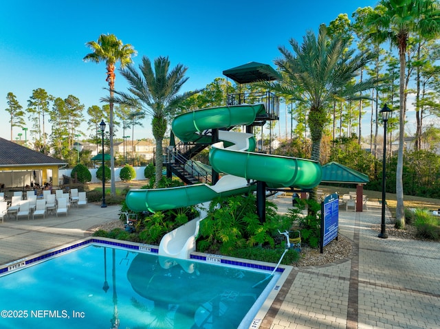 view of pool featuring a playground and a water slide