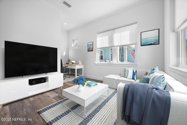 living room with crown molding and dark wood-type flooring