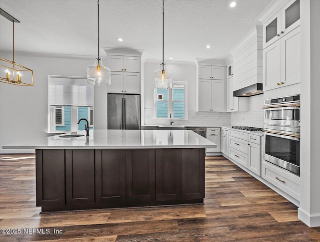 kitchen featuring stainless steel appliances, white cabinets, and decorative light fixtures