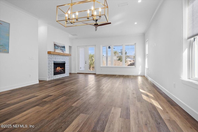 unfurnished living room with crown molding, dark hardwood / wood-style floors, and a chandelier