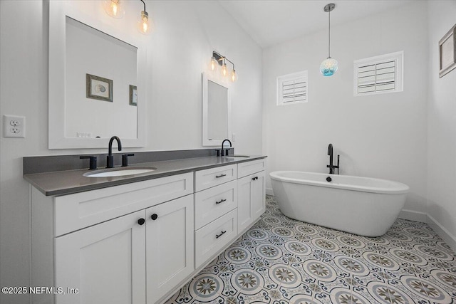 bathroom featuring tile patterned flooring, vanity, and a tub