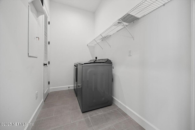 washroom with washing machine and dryer and light tile patterned flooring