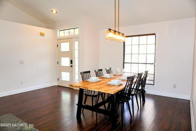 dining area featuring dark hardwood / wood-style flooring, vaulted ceiling, and a chandelier